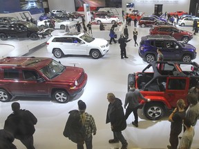 Auto enthusiasts walk through the Chrysler display at the 2016 Montreal International Auto Show at the Palais des congrès in Montreal Jan. 18, 2016.
