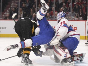 Montreal Canadiens Lars Eller tumbles  in front of goalie Mike Condon after being checked by Boston Bruins Loui Eriksson during second period of National Hockey League game in Montreal Tuesday Jan. 19, 2016.