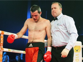 Referee Steve St. Germain leads Stanislas Salmon of France to his corner after stopping his bout against Custio Clayton at a boxing event at the Casino de Montréal Jan. 21, 2016.