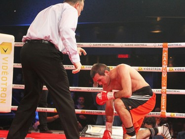 Stanislas Salmon of France falls to one knee after taking a body punch from Custio Clayton of Montreal during boxing event at the Casino de Montréal, Thursday January 21, 2016. Referee Steve St. Germain stopped the fight moments later.