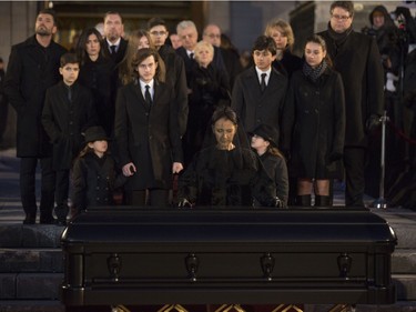 Céline Dion touches the casket that holds her husband René Angélil, behind her are her sons René-Charles, twins Nelson and Eddy, along with more family, at  Notre Dame Basilica, in Montreal, Friday January 22, 2016.
