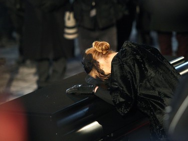 Singer Celine Dion, puts her head on her husband's coffin before getting into the limousine in front of  Notre Dame Basilica in Montreal on Friday January 22, 2016.