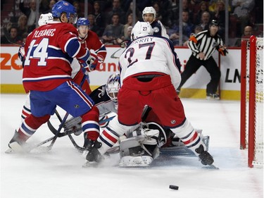 Columbus Blue Jackets goalie Joonas Korpisalo, centre, tries to follow the puck as Montreal Canadiens centre Tomas Plekanec, left, and Columbus Blue Jackets defenceman Ryan Murray crowd him during NHL action at the Bell Centre in Montreal on Tuesday January 26, 2016.