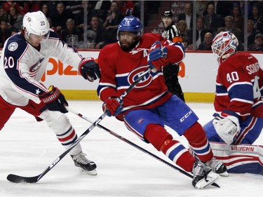 Columbus Blue Jackets left wing Brandon Saad, left, knocks Montreal Canadiens defenceman P.K. Subban's feet out from under him as Montreal Canadiens goalie Ben Scrivens, right, stops a shot during NHL action at the Bell Centre in Montreal on Tuesday January 26, 2016.
