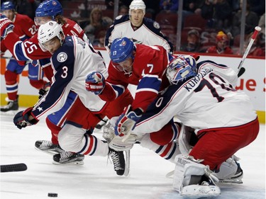 Montreal Canadiens centre Torrey Mitchell gets tripped up by Columbus Blue Jackets goalie Joonas Korpisalo, right, as Columbus Blue Jackets defenceman Seth Jones scrambles for the loose puck during NHL action at the Bell Centre in Montreal on Tuesday January 26, 2016.