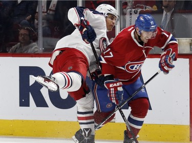 Montreal Canadiens centre Torrey Mitchell, right, grimaces as he is checked by Columbus Blue Jackets left wing Rene Bourque during NHL action at the Bell Centre in Montreal on Tuesday January 26, 2016.