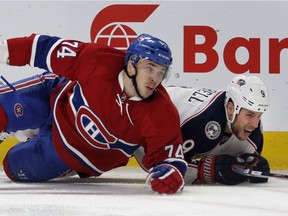 Montreal Canadiens defenceman Alexei Emelin, left, and Columbus Blue Jackets centre Gregory Campbell crash to the ice after hitting each other along the boards during NHL action at the Bell Centre in Montreal on Tuesday January 26, 2016.