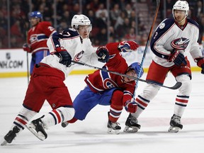 Montreal Canadiens right wing Brendan Gallagher grimaces as he is checked by Columbus Blue Jackets defenceman Ryan Murray, left, as Columbus Blue Jackets defenceman Seth Jones looks on during NHL action at the Bell Centre in Montreal on Tuesday January 26, 2016.