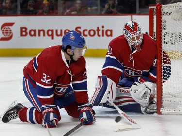 Montreal Canadiens right wing Brian Flynn, left, tries to cover the loose puck as Montreal Canadiens goalie Ben Scrivens reaches to pull it in during NHL action against the Columbus Blue Jackets at the Bell Centre in Montreal on Tuesday Jan. 26, 2016.