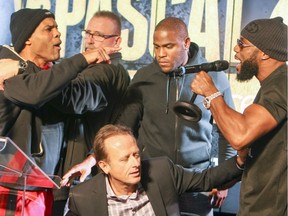 John David Jackson, left, trainer of boxer Sergey Kovalev is restrained from going after Jean Pascal during news conference promoting Saturday's fight in Montreal on Wednesday January 27, 2016.  Caught in the middle is Groupe Interbox president Jean Bedard.