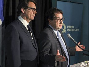 Parti Québécois leader Pierre Karl Peladeau, left, and PQ house leader Bernard Drainville react to provincial cabinet shuffle at the party's office in Montreal Thursday January 28, 2016.
