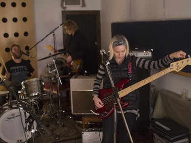 Olga Goreas of the Besnard Lakes tunes her bass as Jace Lasek talks with drummer Kevin Laing at Breakglass Studios in Montreal on Monday, January 4, 2016.
