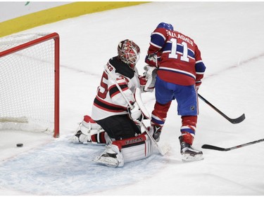 The puck goes through the pads of Devils goalie Cory Schneider on a goal by captain Max Pacioretty, while Schneider is being crowded by Brendan Gallagher during the first period at the Bell Centre on Wednesday.