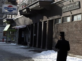 A member of the Hasidic community passes  Outremont's  Congregation Machzikei Torah of Montreal Synagogue on Bernard Ave. in Outremont in this January 2016 photo.