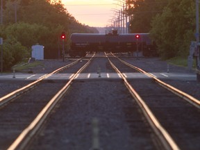 A tank car crosses train tracks.