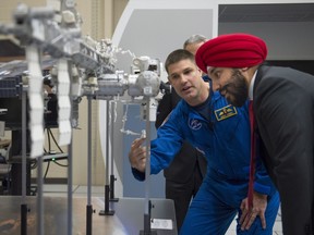 Minister of Innovation, Science and Economic Development Navdeep Bains looks over a model of the International Space Station with Canadian astronaut Jeremy Hansen at the Canadian Space Agency, in St-Hubert, Que., on Thursday, Jan. 7, 2016.
