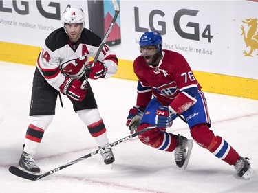 Montreal Canadiens defenseman P.K. Subban is checked by New Jersey Devils centre Adam Henrique during first-period action Wednesday, Jan. 6, 2016, in Montreal.