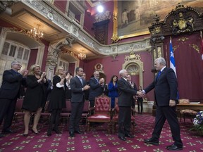 Quebec Premier Philippe Couillard, right, shakes hands with Lt. Gov. J. Michel Doyon during a swearing-in ceremony of his new cabinet, Thursday, January 28, 2016 at the legislature in Quebec City.