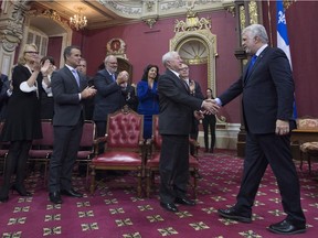 Quebec Premier Philippe Couillard, right, shakes hands with Lt. Gov. J. Michel Doyon during a swearing-in ceremony of his new cabinet, Thursday, Jan. 28, 2016 at the legislature in Quebec City.