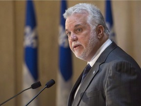 Quebec Premier Philippe Couillard pays tribute to the Quebec victims of terrorism in Burkina Faso and Indonesia, Monday, January 18, 2016 at his office in Quebec City. Couillard will shuffle his cabinet on Thursday for the first time since taking power in 2014.