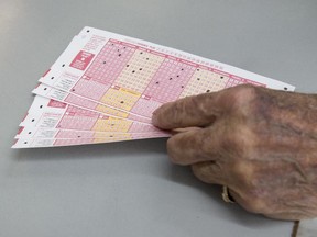 G. Ramos, of Miami Beach, Fla., prepares to buy Powerball lottery tickets at El Presidente Supermarket, Friday, Jan. 8, 2016, in the Little Havana neighborhood of Miami, as the multi-state jackpot reaches $800 million. With ticket sales doubling previous records, the odds are growing that someone will win Saturday's record jackpot, but if no one wins the top prize, next week's drawing is expected to soar past $1 billion.