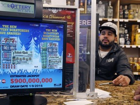 Samir Akhter, the owner of Penn Branch Liquor, works at the Powerball ticket machine, Saturday, Jan. 9, 2016 in Washington. Officials say it's increasingly likely someone will win the $900-million Powerball jackpot, which grew by $100 million only hours before Saturday night's drawing.