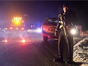 Sgt. Tom Hutchison stands in front of an Oregon State Police roadblock on Highway 395 between John Day and Burns by Oregon State police officers Tuesday, Jan. 26, 2016. Authorities say shots were fired Tuesday during the arrest of members of an armed group that has occupied a national wildlife refuge in Oregon for more than three weeks.