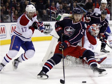 Columbus Blue Jackets' William Karlsson, right, of Sweden, works against Montreal Canadiens' Torrey Mitchell during the second period of an NHL hockey game in Columbus, Ohio, Monday, Jan. 25, 2016.