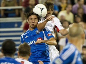 Montreal Impact's Zarek Valentin and New England Revolution's Blake Brettschneider leap for the ball during second half MLS soccer action in Montreal on Wednesday, July 18, 2012.