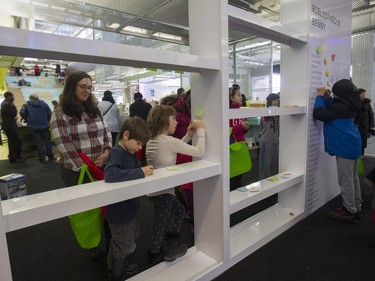 Dominique Forgeard watches as her niece Azure Klopp and son Adrien Cropas make drawings on post-its at an area where children were encouraged to do so at the N.D.G. Cultural Centre and Benny Library in Montreal on Saturday, Feb. 6, 2016, at an open house.