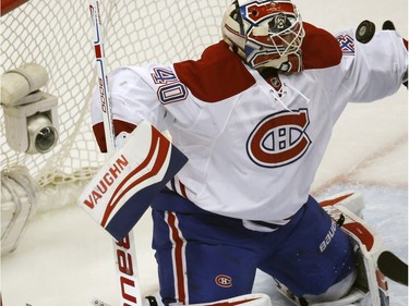 Montreal Canadiens goalie Ben Scrivens deflects a shot against the Colorado Avalanche in the first period of an NHL hockey game Wednesday, Feb. 17, 2016, in Denver.