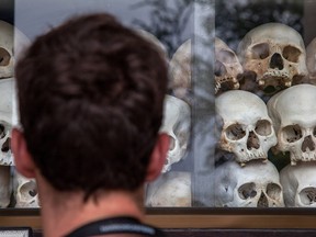 A visitor looks at the main stupa in Choeung Ek Killing Fields, filled with thousands of skulls of those killed during the Pol Pot regime, in Phnom Penh, Cambodia.