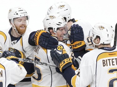 Nashville Predators' Craig Smith is surrounded by teammates Ryan Ellis, left, Ryan Johansen, rear, and Anthony Betitto after scoring the winning shootout goal against the Canadiens in Montreal on Monday, Feb. 22, 2016.