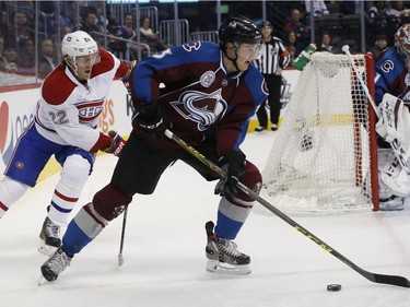 Colorado Avalanche defenceman Chris Bigras, right, clears the puck from his zone with Montreal Canadiens right wing Dale Weise in pursuit in the second period of an NHL hockey game Wednesday, Feb. 17, 2016, in Denver.