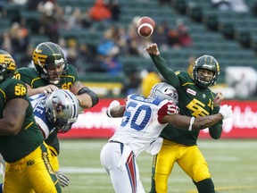 Edmonton's Mike Reilly (13) is tackled by Montreal's Henoc Muamba (50) during the first half of a CFL game between the Edmonton Eskimos and the Montreal Alouettes at Commonwealth Stadium in Edmonton on Nov. 1, 2015.