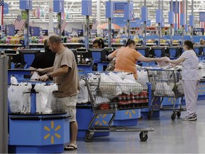 In this June 4, 2015 file photo, shoppers check out at a Wal-Mart Supercenter store in Springdale, Ark.
