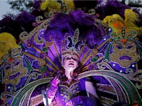 A Maid from the royal court of Endymion throws beads as the Krewe of Endymion Mardi Gras parade rolls through New Orleans, Saturday, Feb. 6, 2016.