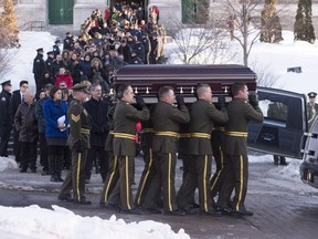 Joannie Vaillancourt, left, wife of Lac-Simon police officer Thierry LeRoux, follows the casket carried by Surete du Quebec police officers at the end of the funeral service for police officer Thierry LeRoux Friday, February 26, 2016 in Saguenay, Que. LeRoux died tragically in a shooting in Lac-Simon Que. on Feb. 13, 2016.