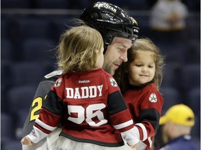 Pacific Division forward John Scott carries his children onto the ice after being named the most valuable player in the NHL hockey all-star game Sunday, Jan. 31, 2016, in Nashville, Tenn.