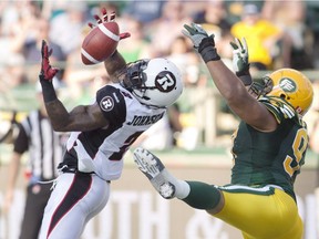 Ottawa Redblacks' Jovon Johnson (2) blocks the pass to Edmonton Eskimos' Eddie Steele (97) during first half action in Edmonton, Alta., on Thursday July 9, 2015.