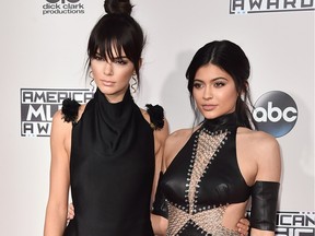 Kendall Jenner, left, and Kylie Jenner are taking on their sister Kim Kardashian's Kimoji game. Kendall and Kylie rocketed to the top of the download charts when the title from Glu Mobile debuted Wednesday, Feb. 17, 2016.