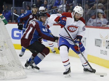 Montreal Canadiens left wing Lucas Lessio, front, looks to wrap around the net for a shot as Colorado Avalanche defenceman Andrew Bodnarchuk defends in the third period of an NHL hockey game Wednesday, Feb. 17, 2016, in Denver. Colorado won 3-2.