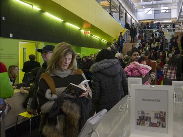 Lucie Côté looks at a book at the N.D.G. Cultural Centre and Benny Library in Montreal on Saturday, Feb. 6, 2016, at an open house.