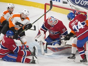 Montreal Canadiens goaltender Mike Condon (39) stops a shot against the Philadelphia Flyers as Flyers' Scott Laughton (21), Michael Raffl (12) and Canadiens' Greg Pateryn (6) and Alexei Emelin (74) look for the rebound during first period NHL hockey action in Montreal, Friday, Feb. 19, 2016.