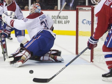Montreal Canadiens goalie Mike Condon, left, makes a kick save against Washington Capitals center Mike Richards during the second period of an NHL hockey game, on Wednesday, Feb. 24, 2016, in Washington.