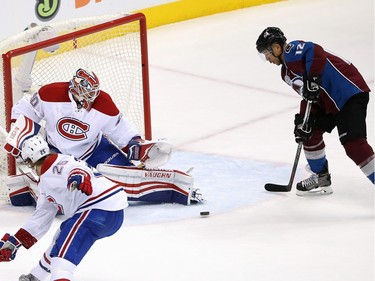 Jarome Iginla #12 of the Colorado Avalanche collects the puck to score the game-winning goal against goalie Ben Scrivens #40 of the Montreal Canadiens in the third period at Pepsi Center on February 17, 2016 in Denver, Colorado. The Avalanche defeated the Canadiens 3-2.