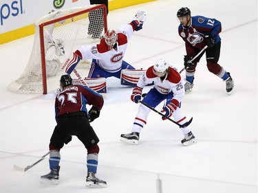 Mikhail Grigorenko #25 of the Colorado Avalanche collects an assist as he passes the puck past Jacob De La Rose #25 of the Montreal Canadiens to Jarome Iginla #12 of the Colorado Avalanche to score the game-winning goal against goalie Ben Scrivens #40 of the Montreal Canadiens in the third period at Pepsi Center on February 17, 2016 in Denver, Colorado. The Avalanche defeated the Canadiens 3-2.