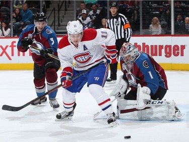 Brendan Gallagher #11 of the Montreal Canadiens looks to control the puck against Chris Bigras #3 of the Colorado Avalanche as goalie Semyon Varlamov #1 of the Colorado Avalanche defends the goal at Pepsi Center on February 17, 2016 in Denver, Colorado.