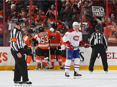 Habs' Tomas Fleischmann grimaces as Flyers' Brayden Schenn celebrates with teammates after scoring a power-play goal against Montreal during the first period on February 2, 2016 in Philadelphia.
