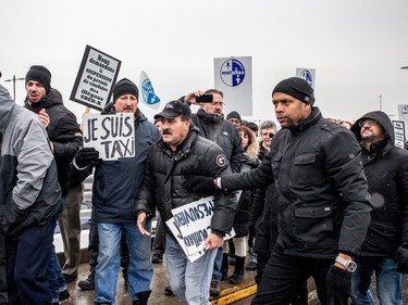 Montreal taxi drivers participate in a protest rally against Uber at Trudeau airport on Wednesday, Feb. 10, 2016.